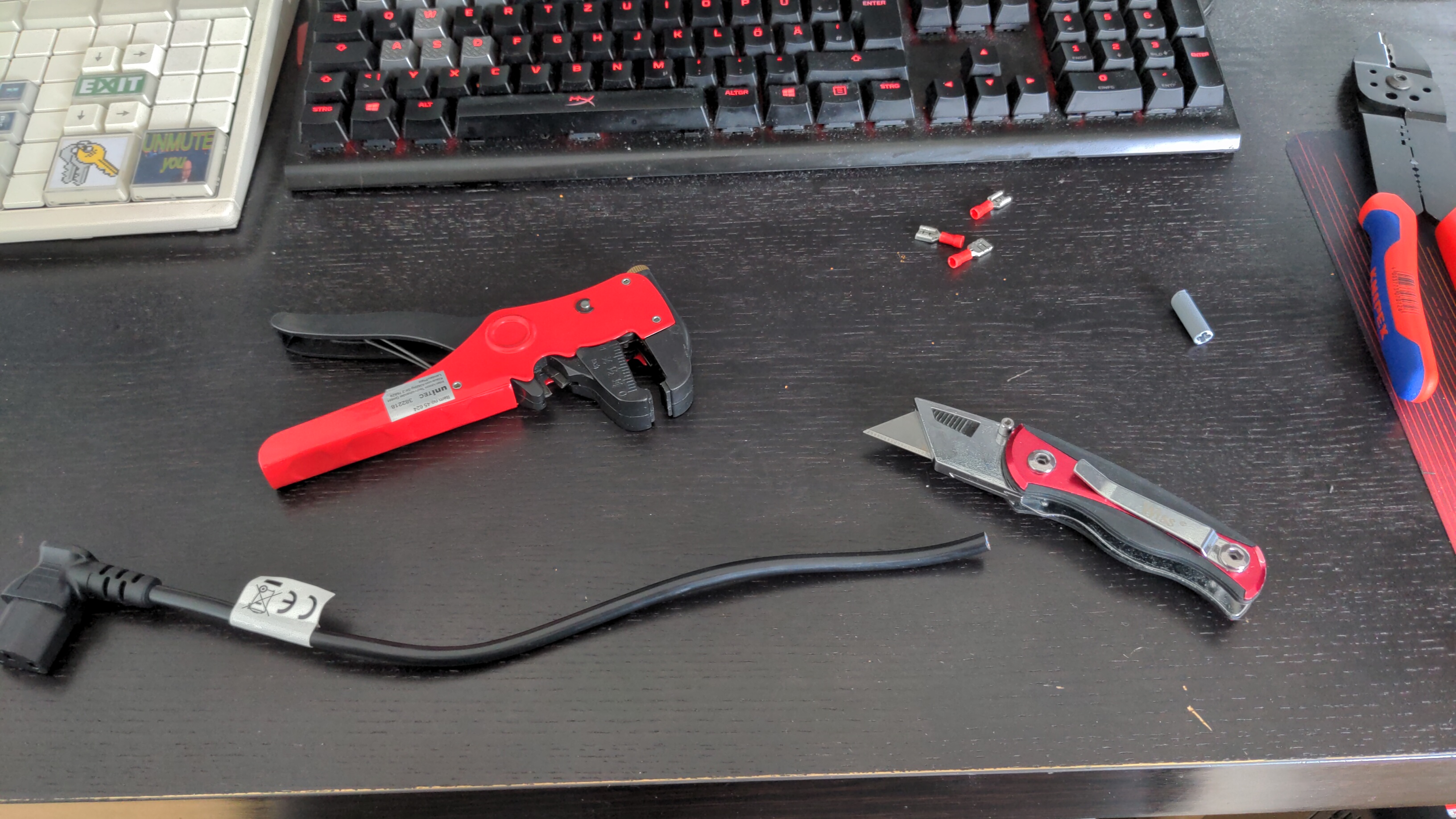 A cable, a wire cutter, and a cutter knife on a desk
